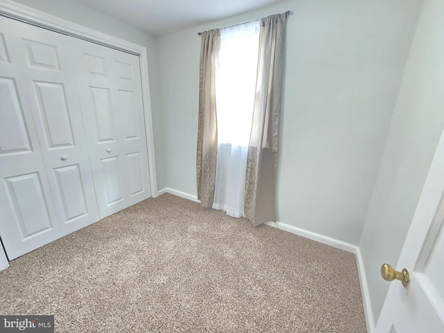 unfurnished bedroom featuring a closet and light carpet