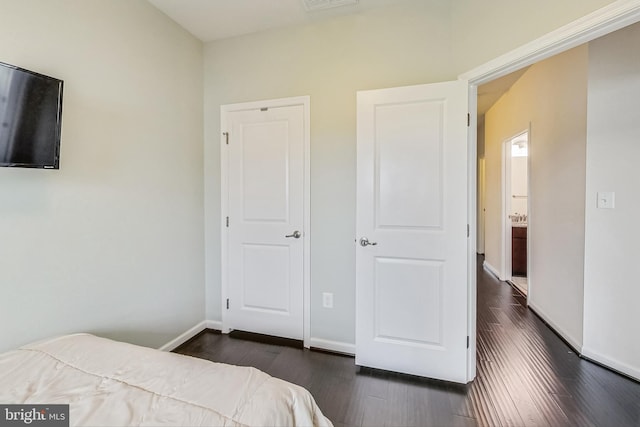 bedroom with dark wood-type flooring