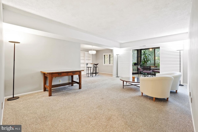 carpeted living room with a chandelier