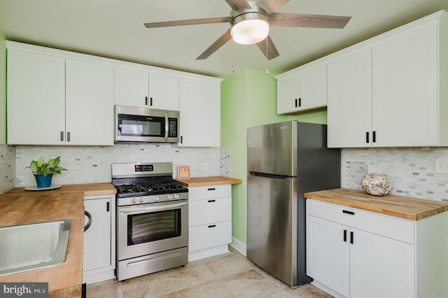 kitchen featuring butcher block counters, stainless steel appliances, and white cabinets