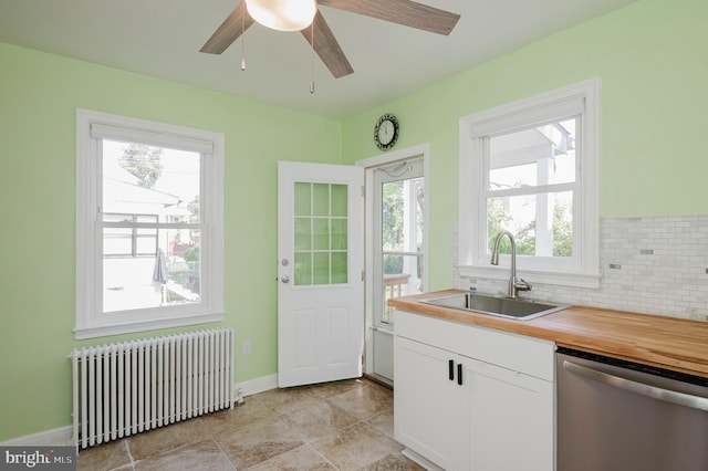 kitchen with white cabinets, backsplash, dishwasher, radiator, and sink