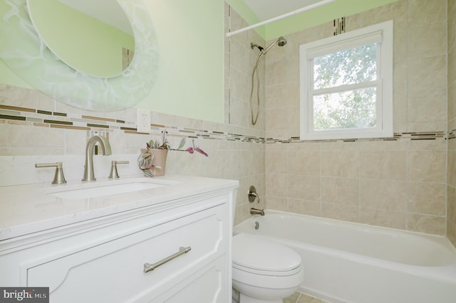 full bathroom with vanity, tile walls, tiled shower / bath combo, and toilet