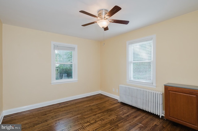 empty room featuring radiator, ceiling fan, and dark wood-type flooring