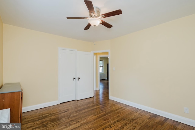 unfurnished bedroom featuring ceiling fan and dark wood-type flooring