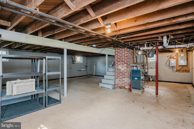 basement featuring a wall unit AC, electric panel, and a wealth of natural light