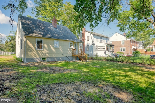 rear view of house featuring a yard