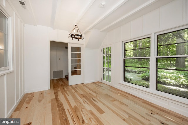 interior space featuring beam ceiling, light hardwood / wood-style floors, and plenty of natural light