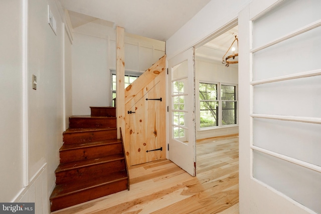 staircase with an inviting chandelier and hardwood / wood-style flooring