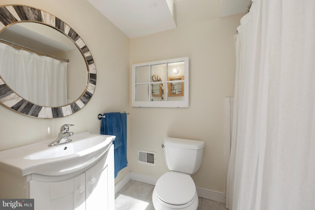 bathroom with tile patterned flooring, vanity, and toilet