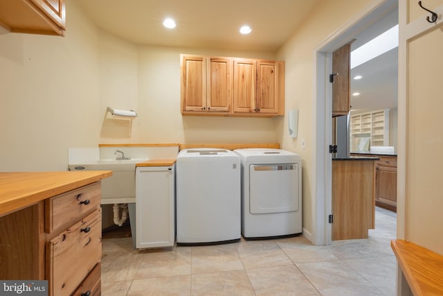 laundry area featuring cabinets, light tile patterned floors, and washing machine and dryer