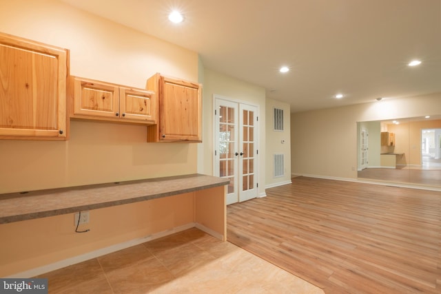 kitchen with light wood-type flooring, light brown cabinetry, and french doors