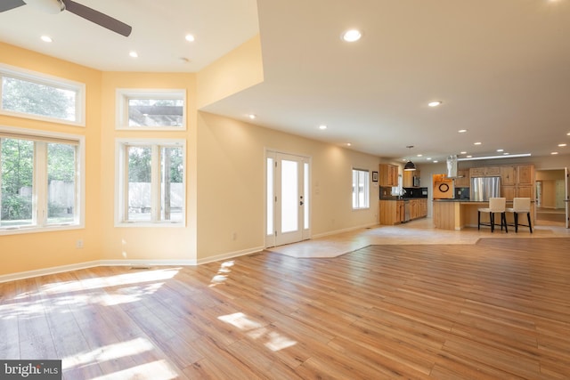 unfurnished living room featuring light hardwood / wood-style floors and ceiling fan