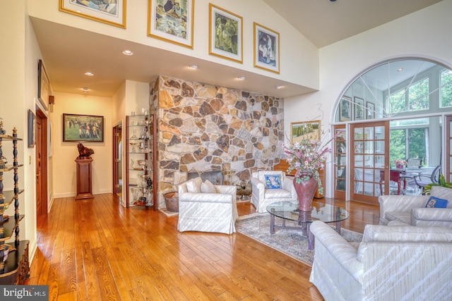 living room featuring high vaulted ceiling and light hardwood / wood-style floors