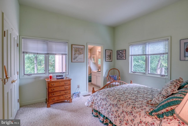 carpeted bedroom featuring ensuite bath