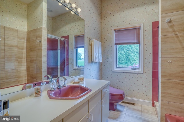 bathroom featuring vanity, toilet, a shower with door, and tile patterned floors