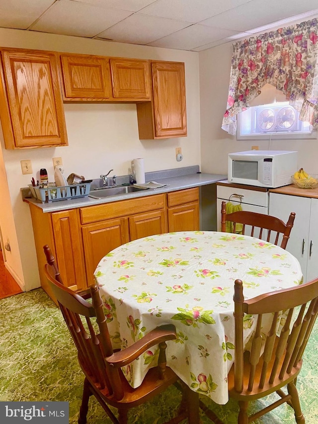 kitchen with a paneled ceiling and sink