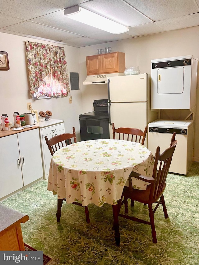 dining room featuring a drop ceiling, stacked washer / dryer, and electric panel