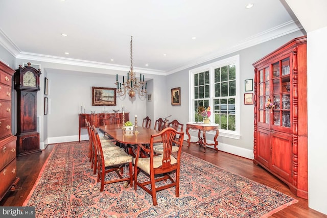 dining room with an inviting chandelier, crown molding, and dark hardwood / wood-style flooring