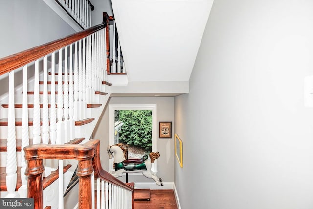 stairs featuring lofted ceiling and hardwood / wood-style floors