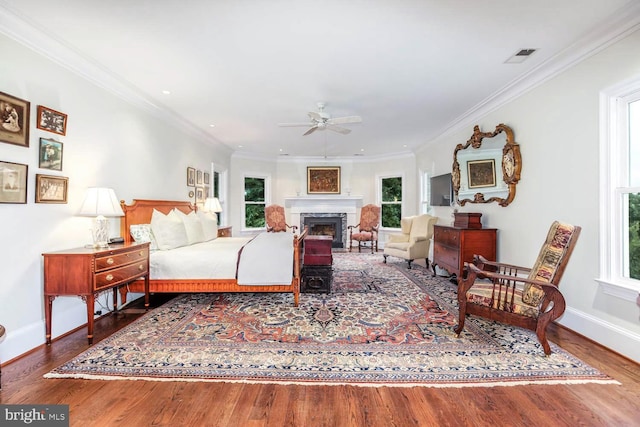 bedroom with multiple windows, wood-type flooring, and ceiling fan