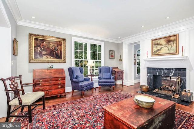 living room with crown molding, a high end fireplace, and wood-type flooring