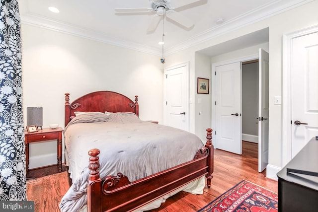 bedroom with hardwood / wood-style floors, crown molding, and ceiling fan