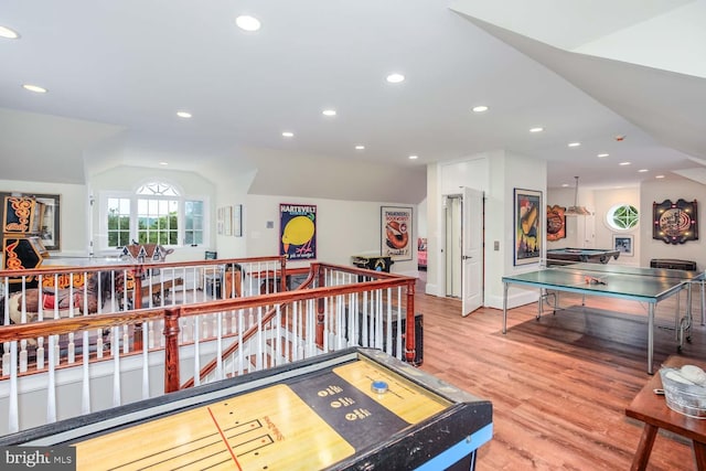 recreation room with wood-type flooring and lofted ceiling