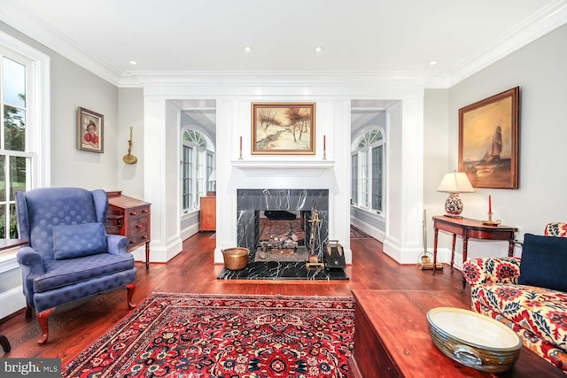 living room with a high end fireplace, crown molding, and dark hardwood / wood-style flooring