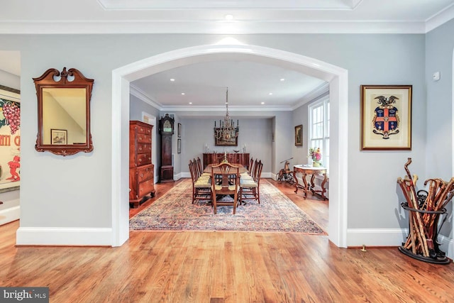 dining space with crown molding and light hardwood / wood-style flooring