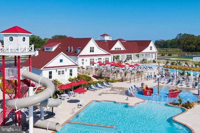 view of swimming pool with a water slide and a patio area