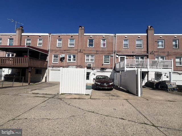 rear view of property with a garage and a deck