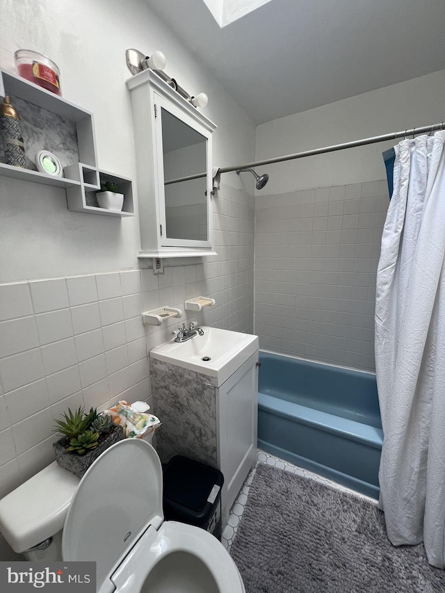 full bathroom with vanity, tile patterned flooring, shower / bath combo with shower curtain, tile walls, and toilet