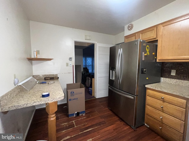 kitchen featuring dark wood-type flooring, stainless steel fridge with ice dispenser, and backsplash