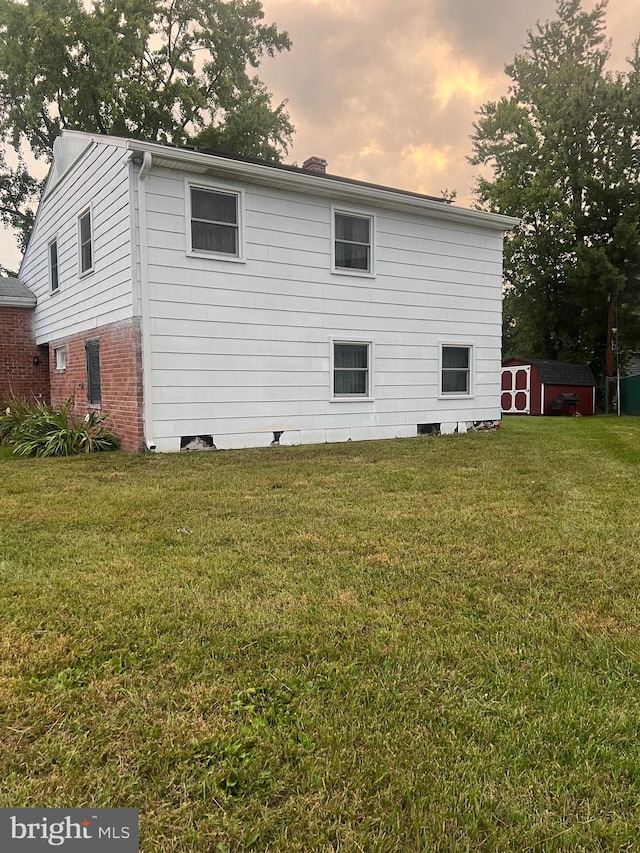 property exterior at dusk with a yard