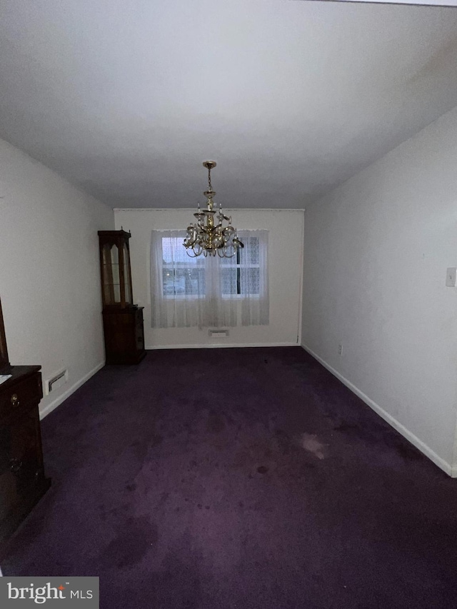 unfurnished dining area with a chandelier and dark colored carpet