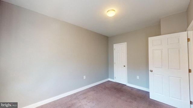 unfurnished bedroom featuring dark carpet