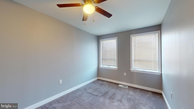 carpeted spare room with ceiling fan