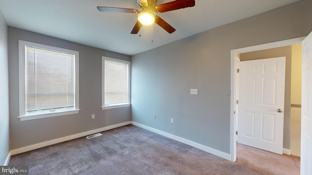 carpeted empty room featuring ceiling fan