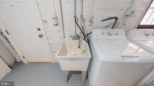 clothes washing area featuring washing machine and clothes dryer and sink