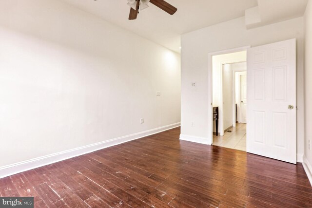 spare room with dark hardwood / wood-style floors and ceiling fan