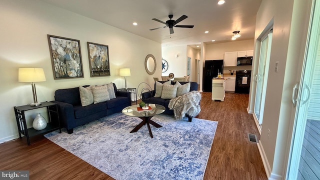 living room featuring dark wood-type flooring and ceiling fan