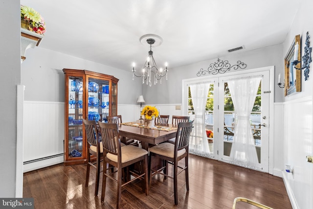 dining area with an inviting chandelier, a baseboard heating unit, and dark hardwood / wood-style floors