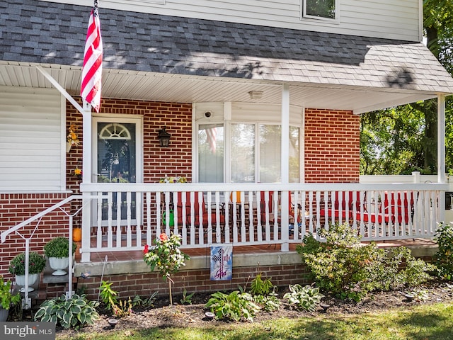 view of exterior entry featuring covered porch