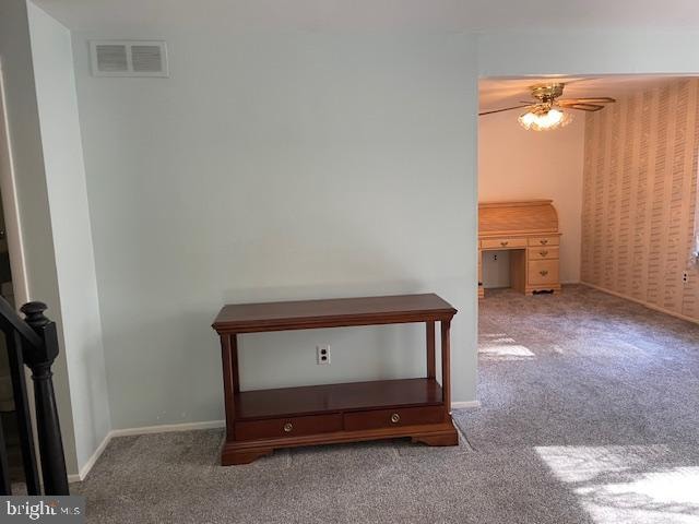 interior space featuring ceiling fan and carpet