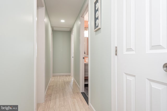 hallway with light hardwood / wood-style floors