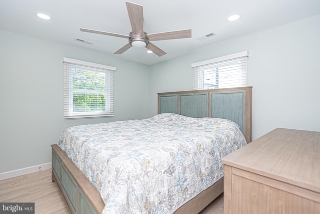 bedroom with light wood-type flooring, multiple windows, and ceiling fan