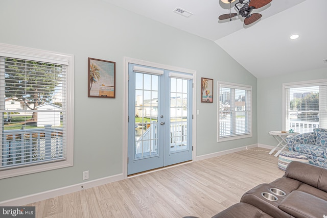 living room featuring light wood-type flooring, lofted ceiling, ceiling fan, and french doors