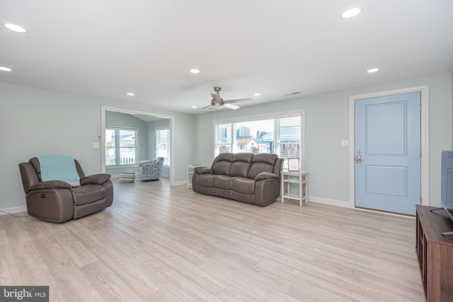 living room featuring light hardwood / wood-style flooring, a wealth of natural light, and ceiling fan