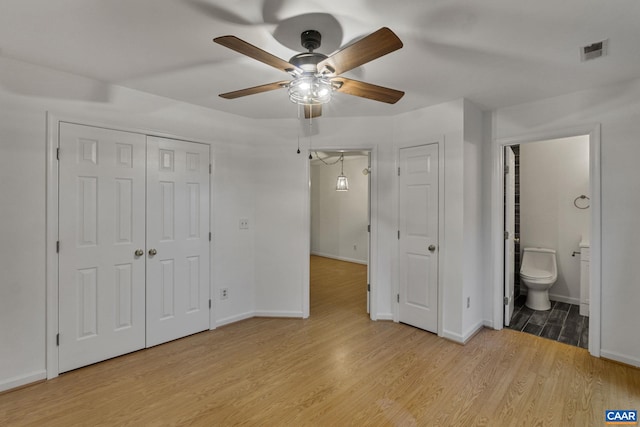 unfurnished bedroom featuring ensuite bath, ceiling fan, and light hardwood / wood-style flooring