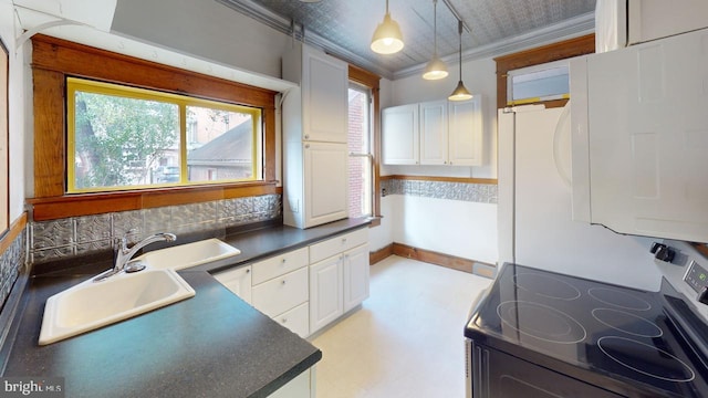 kitchen with electric range, dark countertops, white cabinetry, a sink, and decorative light fixtures
